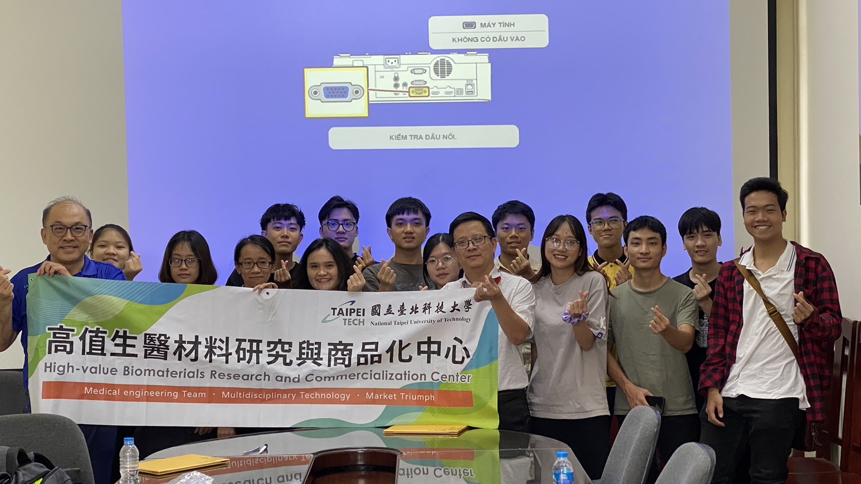 本中心教授與學生們和HUST Biomedical Engineering Group  的教授與學生們共同舉著中心布條合影。