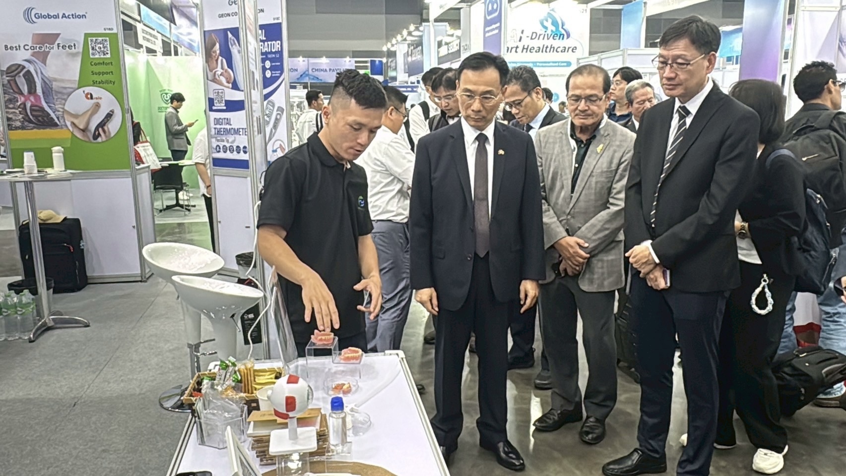 Dr. Yu-Cheng Chang explains the exhibits at the booth to distinguished guests