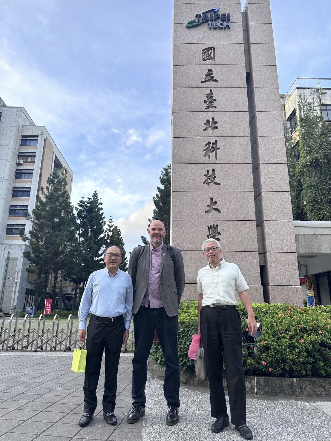 方旭偉教授、笠井均教授以及 Liam Grover 教授(HTI主任)在北科大校門口合照留影。