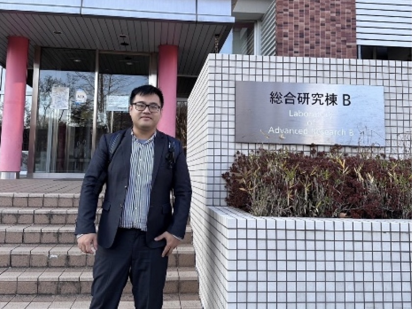 本中心團隊成員站在筑波大學的綜合研究B棟前,與招牌合照。