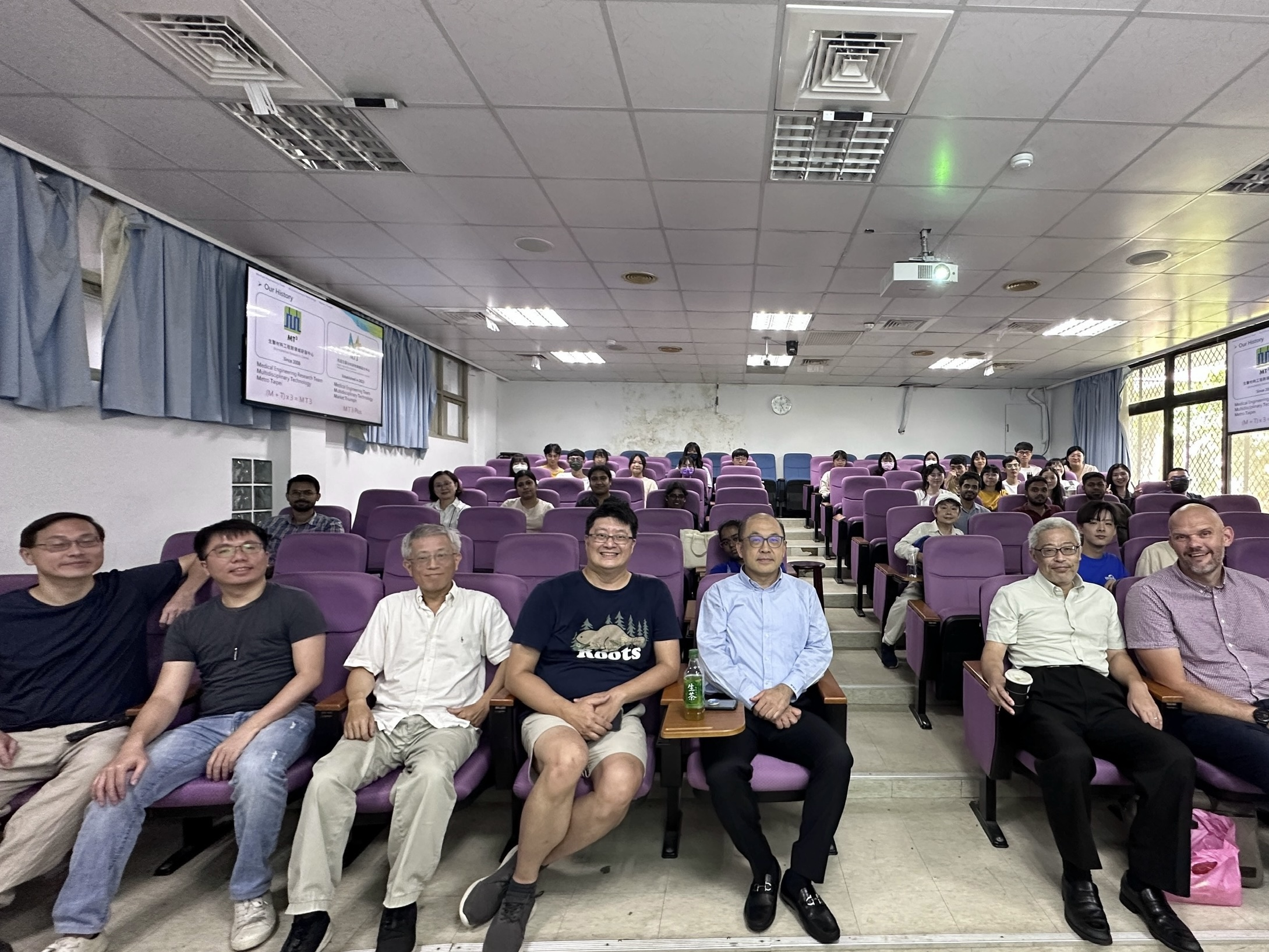 教授們坐在台下與前來聽演講的學生們合影留念。