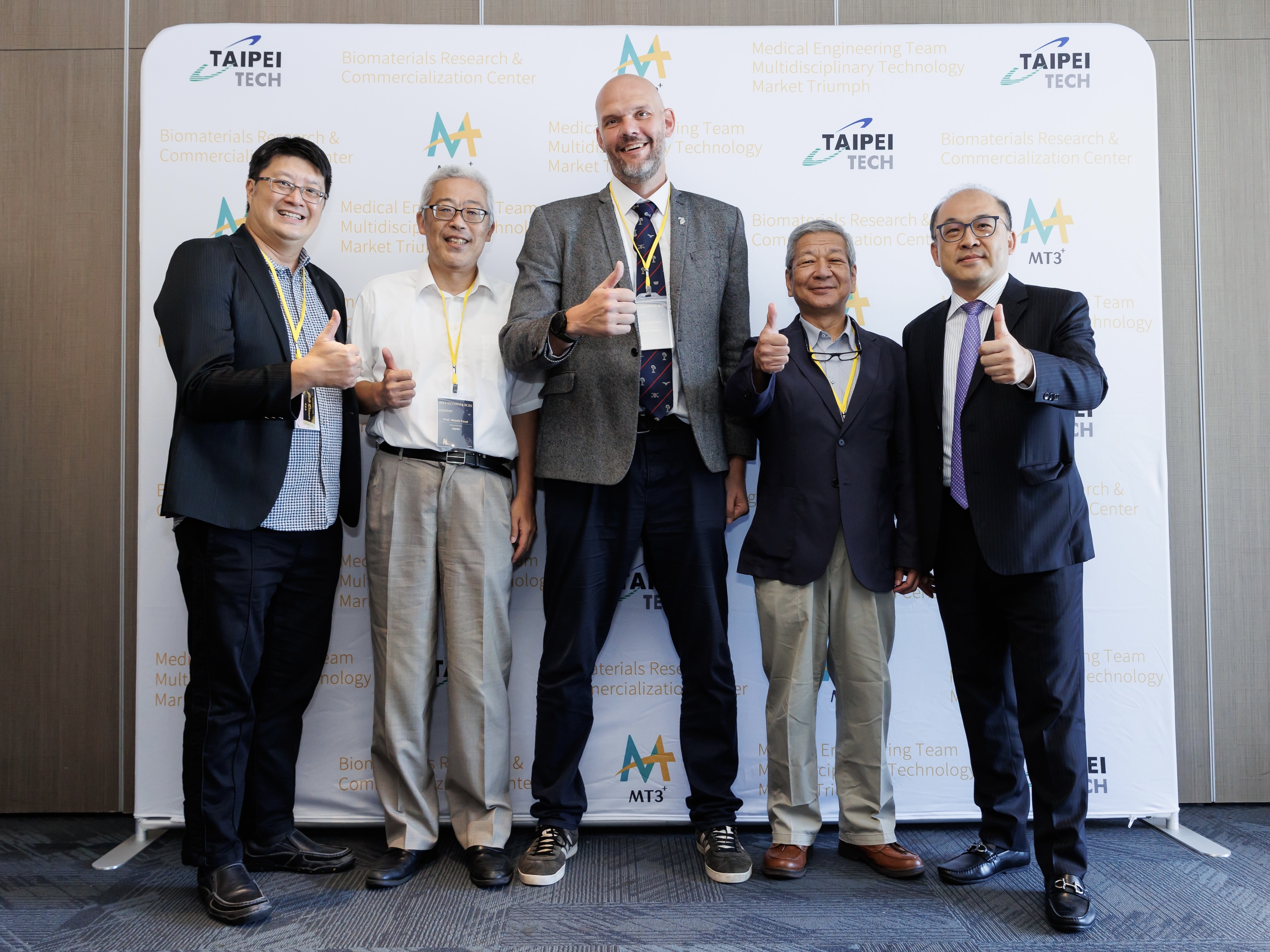 一眾教授們與貴賓站在中心看板前比讚合影留念。