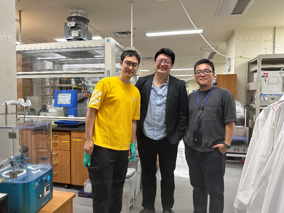 Professors and students pose for a group photo together in a laboratory in Japan.