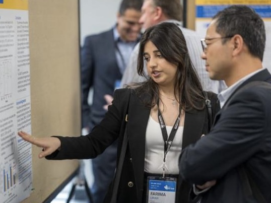 Professor Cho-Pei Jiang listening to a student presenting their research project.