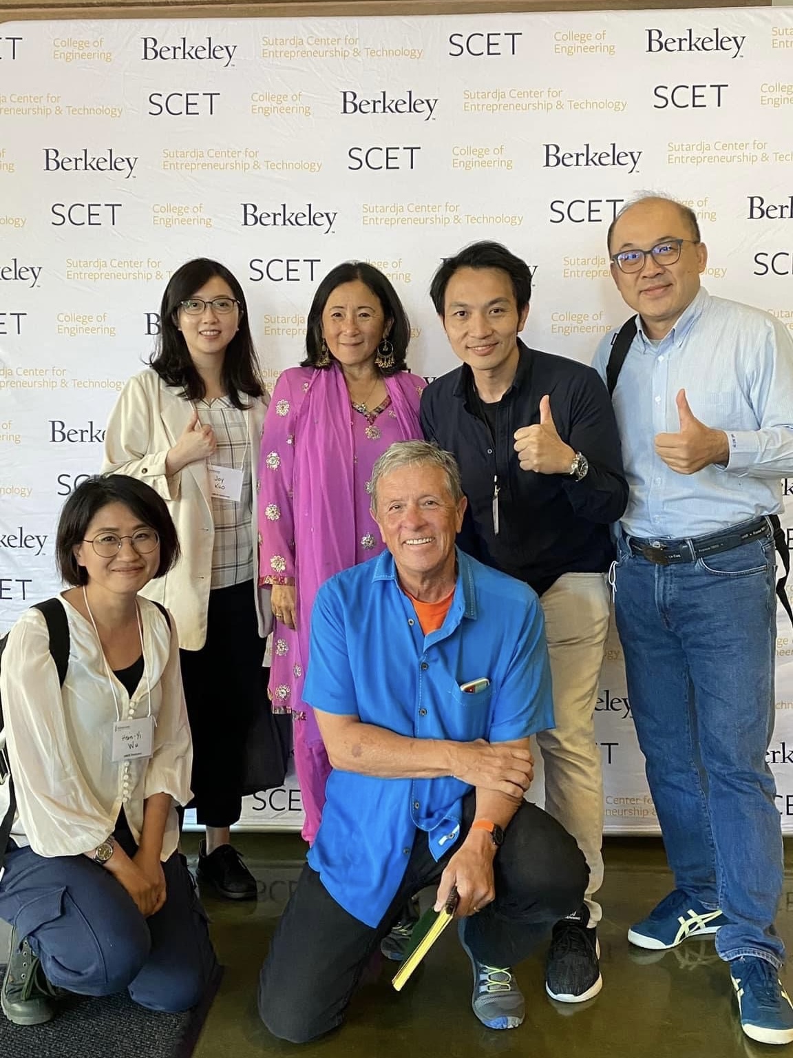 Professor Hsu-Wei Fang and the entrepreneurship instructors pose with thumbs up in front of the event backdrop.