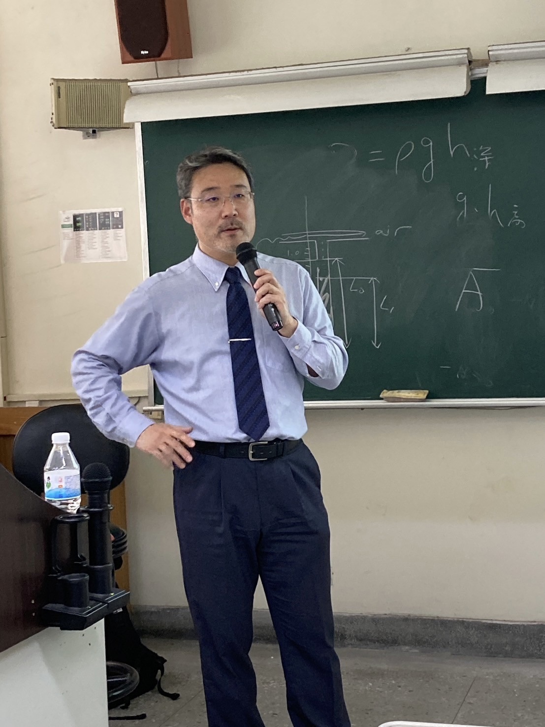 Professor Akira Matsumoto giving a presentation on stage.