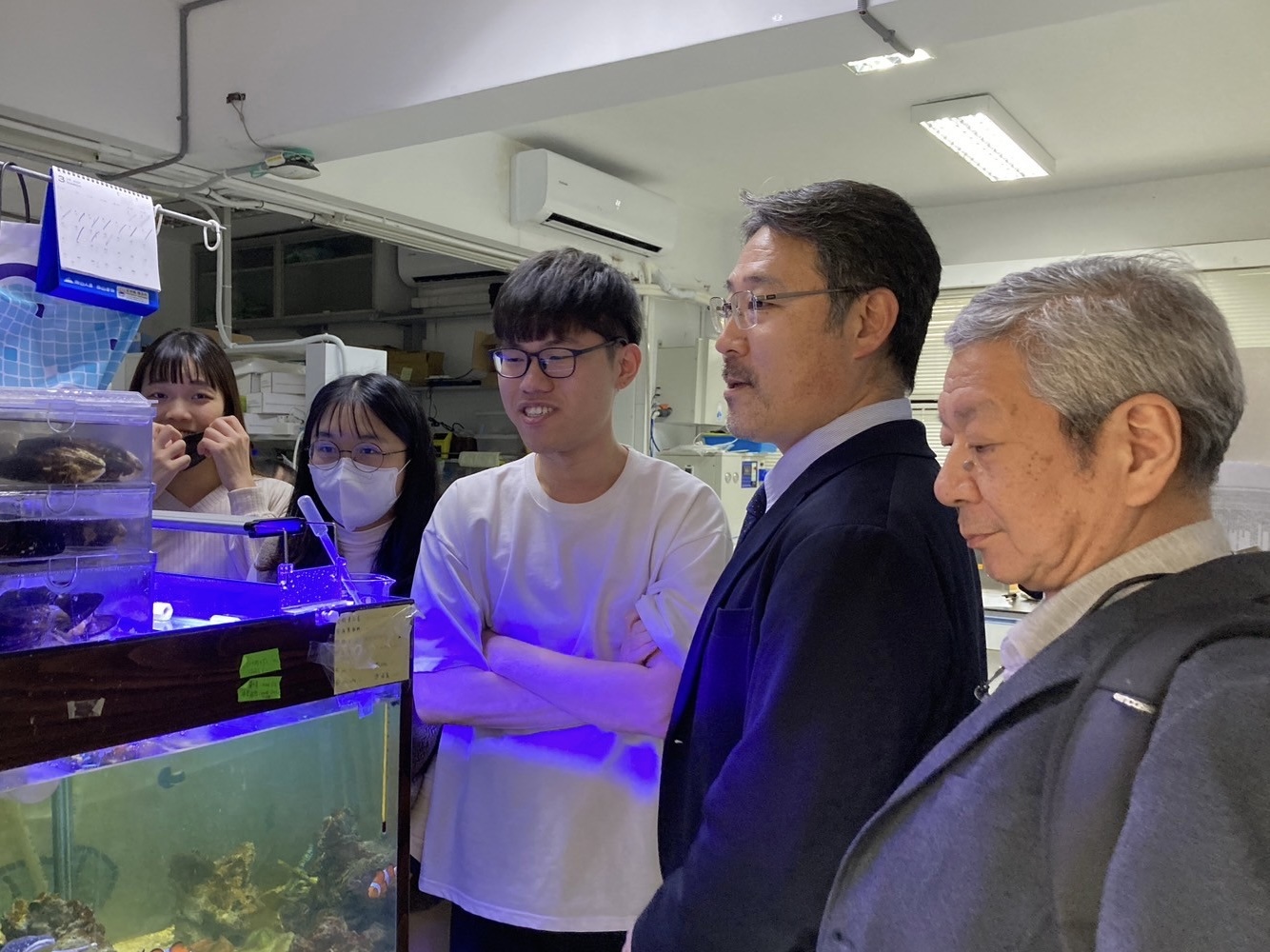 Professor Akira Matsumoto listens to a laboratory student presenting their research.