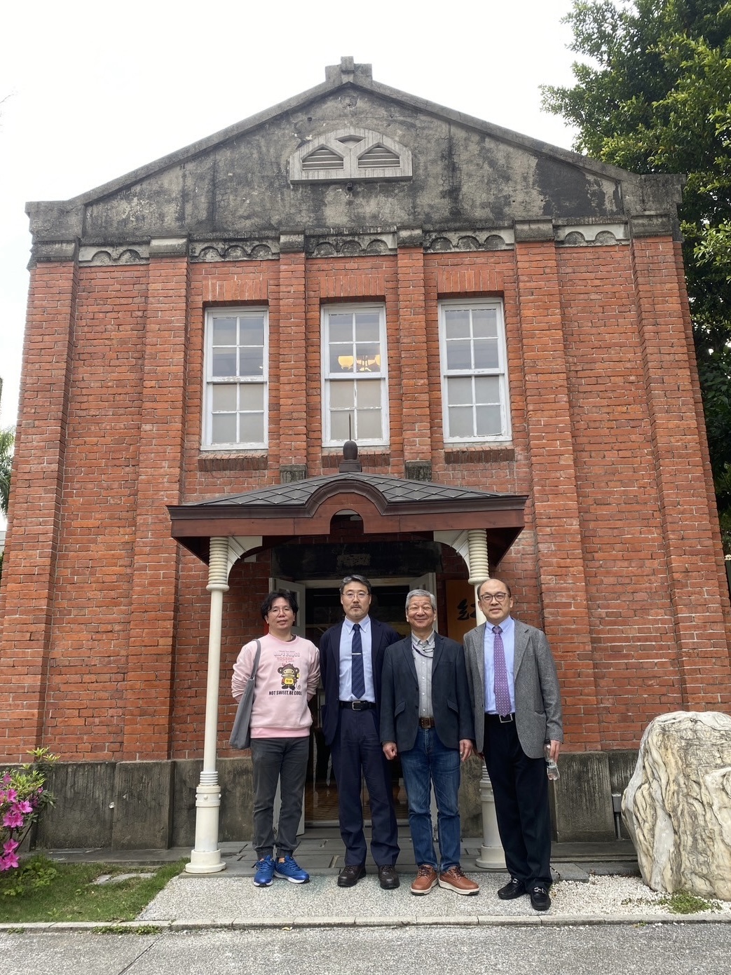 Professor Akira Matsumoto poses for a photo in front of the Red House, a landmark of National Taipei University of Technology.