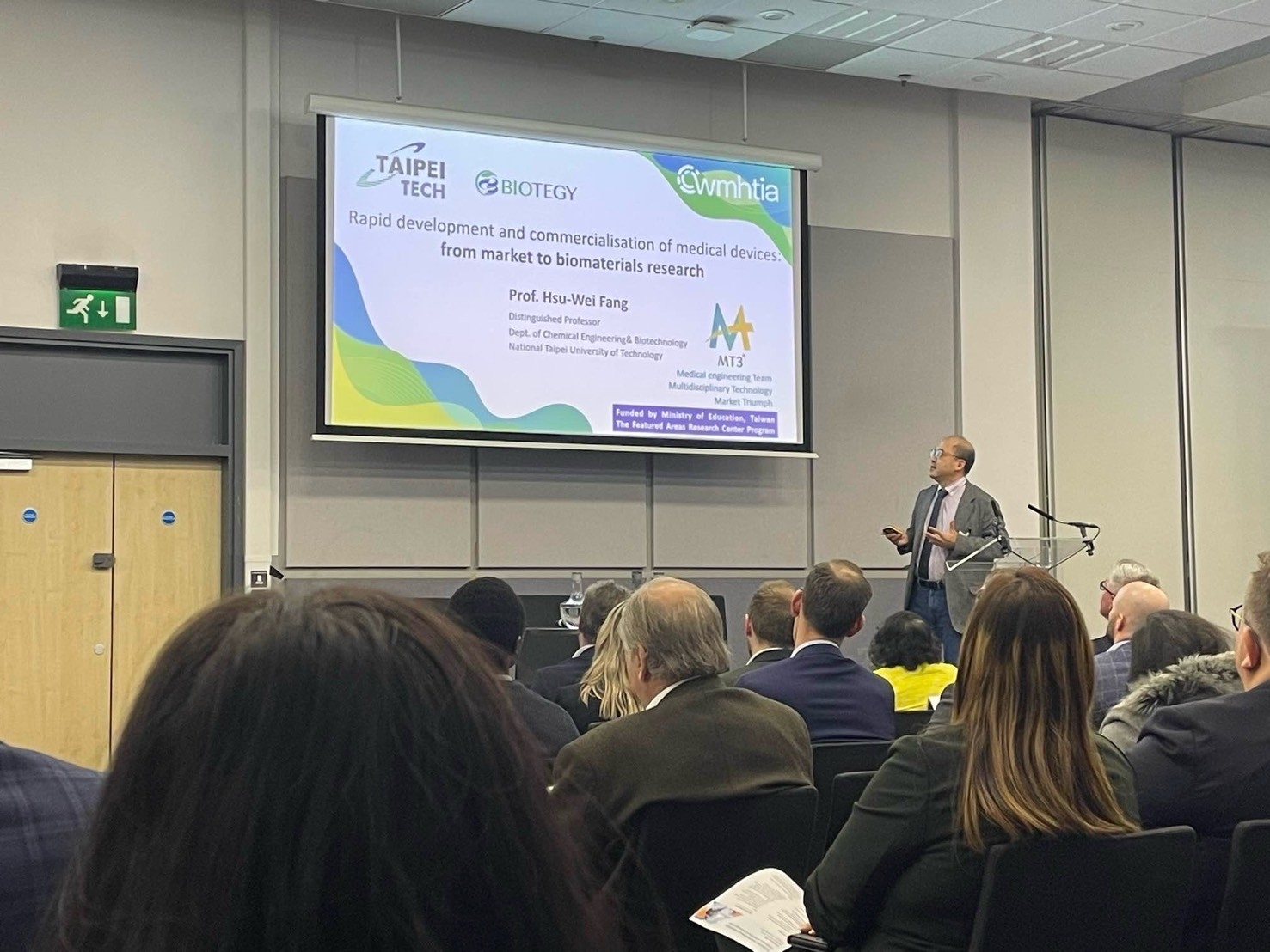 Professor Hsu-Wei Fang delivers a keynote presentation on stage 01.