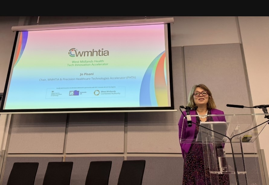 Jo Pisani, Chair of the WMHTIA consortium, delivers a presentation on stage.