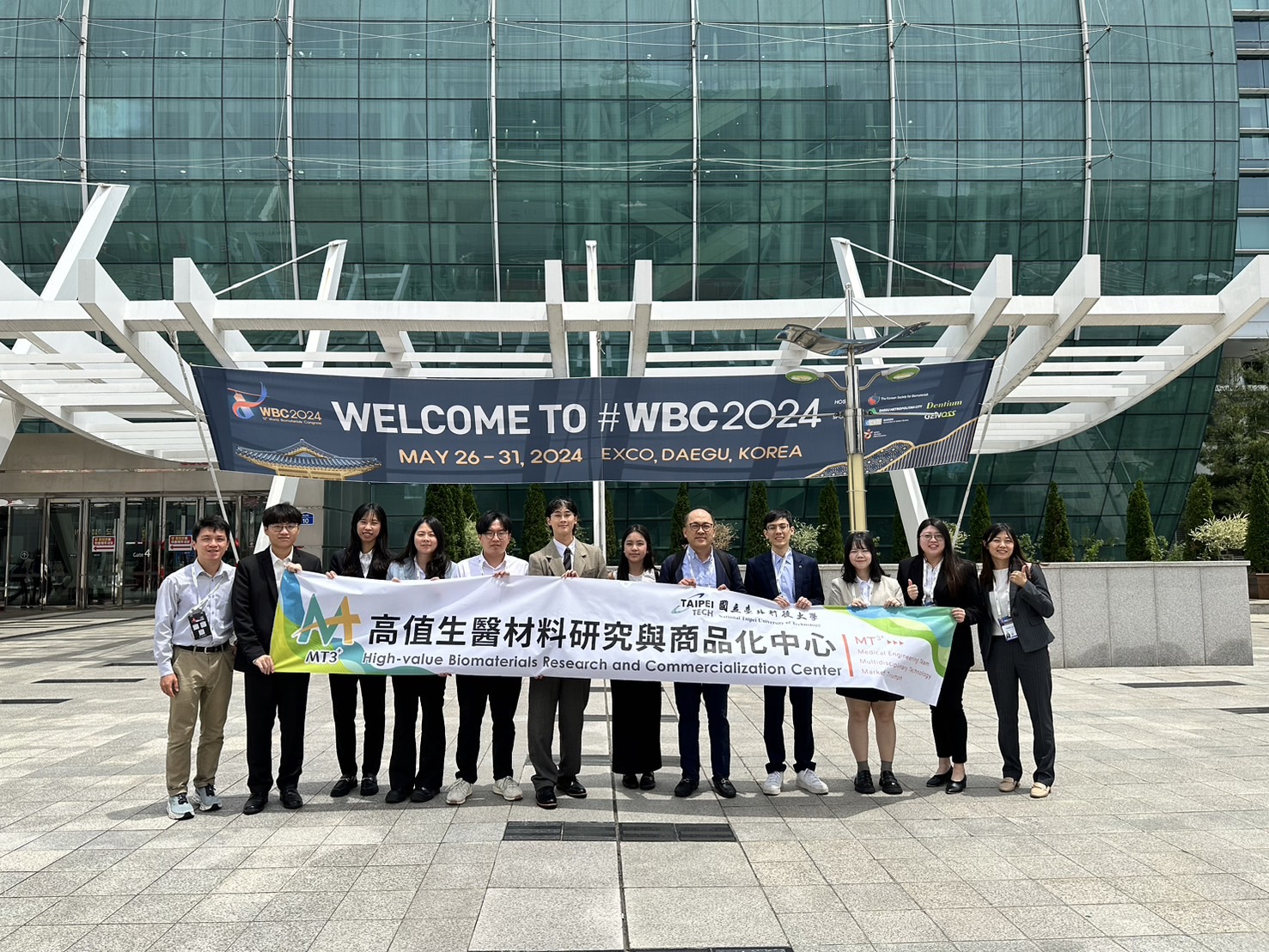 Group photo of all participants holding the Center’s banner outside the venue